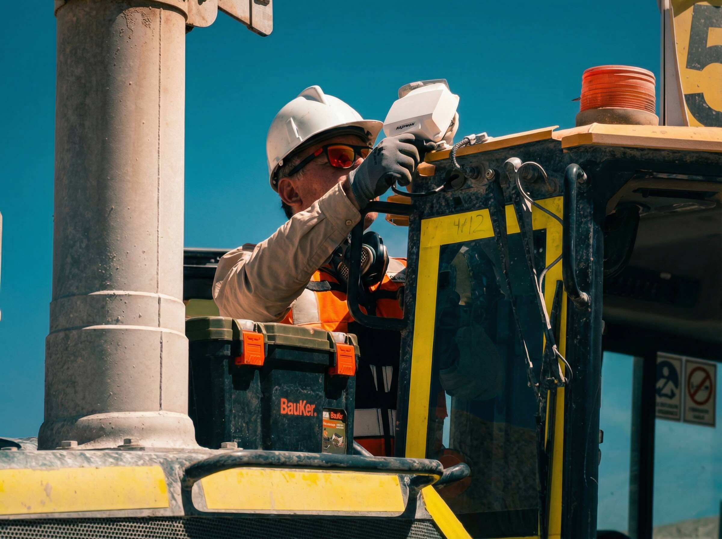 Technician installing a Trakion device on heavy machinery